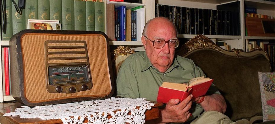 A02 - 19980907 - ROMA - ALR - CAMILLERI ''MOSTRA'' IL SUO LESSICO: ''TIRAMI DUE FOTOGRAFIE'' - Lo scrittore Andrea Camilleri ''assittato'' sul divano preferito della sua casa romana, immerso nella lettura, sbircia l' obiettivo del fotografo. MARIO DE RENZIS/ANSA/DEF